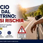 Automobilista guida con il braccio fuori dal finestrino durante l’estate mentre il Codice della Strada avverte sui rischi di multa e perdita di punti patente.