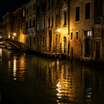 Canale di Venezia di notte con riflessi delle luci sull’acqua, scena della tragedia del giovane annegato a San Polo
